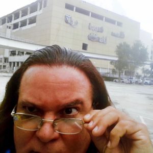 Maverick Artist Victor-Hugo Vaca II In Front Of Skeletal Remains Of The Miami Herald Building Before It Is Imploded, Bulldozed & Scrapped Due To Declining Public Trust In Reporting & Declining Sales & Circulation